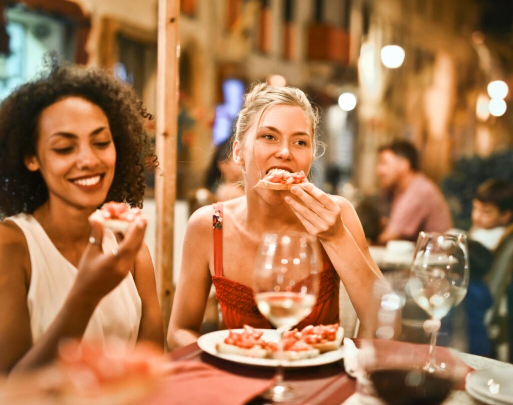 Frau beißt genüsslich in eine Pizza Kulinarische Vielfalt Wie der Streetfood-Trend unsere Küchen revolutioniert